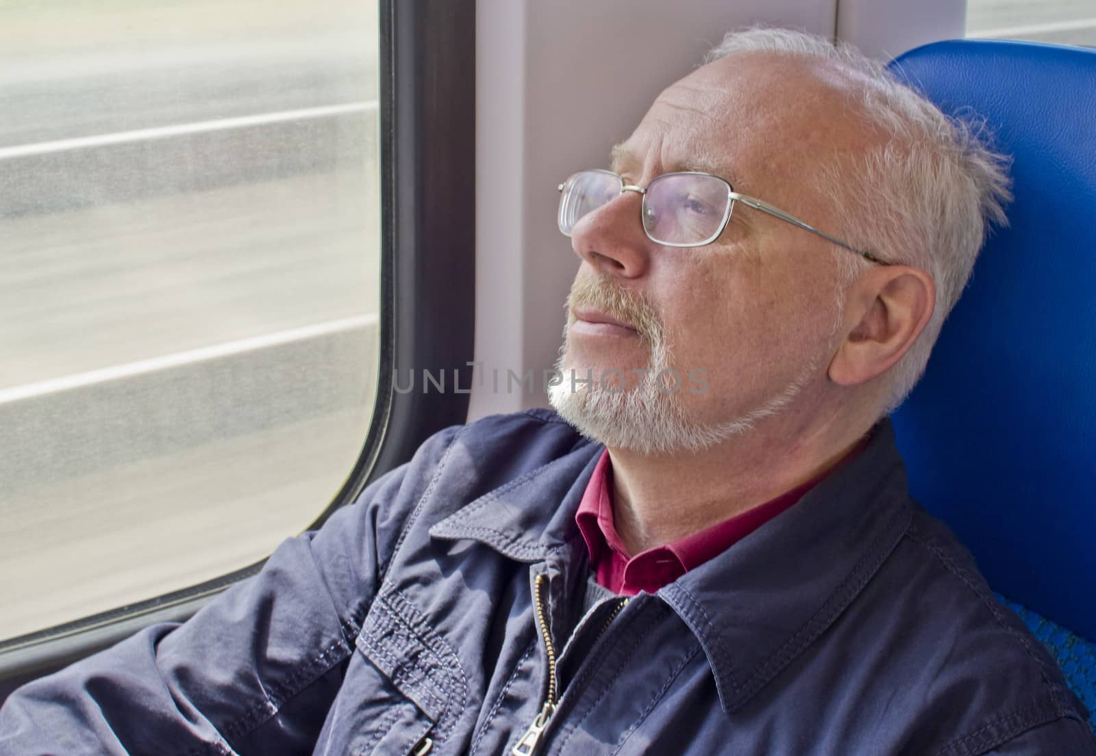 Relaxed old man sitting near the window in the carriage