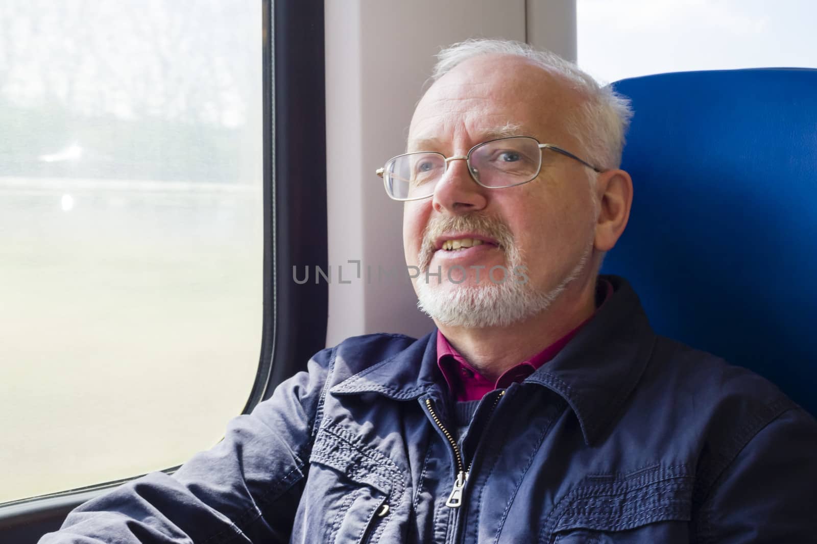 Relaxed old man sitting near the window in the carriage