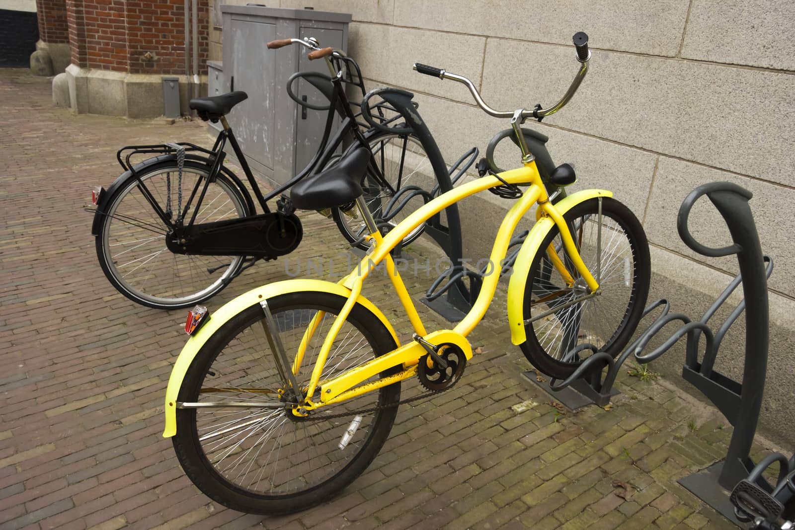 yellow bike with flat tyre parked in a bicycle parking by Tetyana