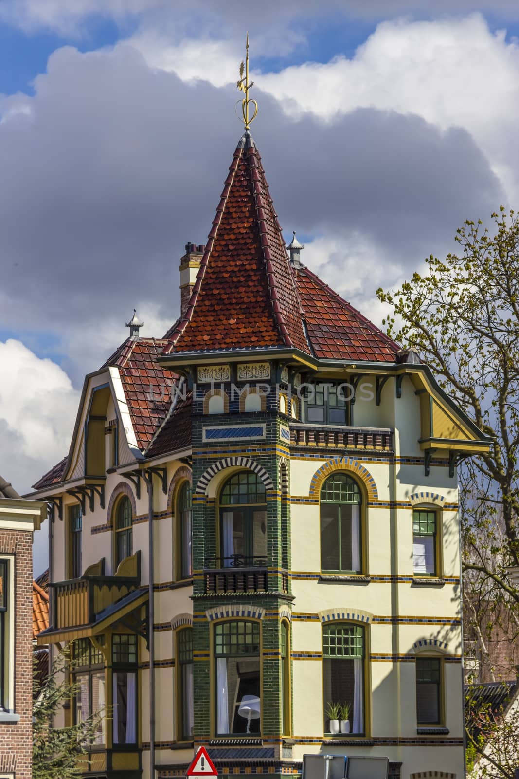 colorful house in Alkmaar against a cloudy sky by Tetyana