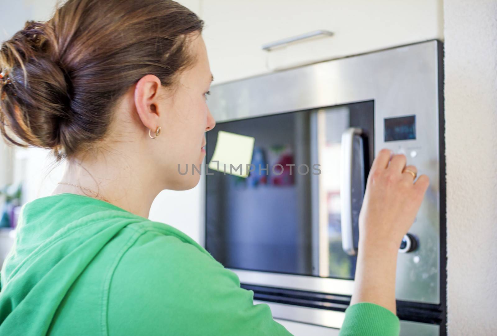 woman cooking with a microwave by Tetyana