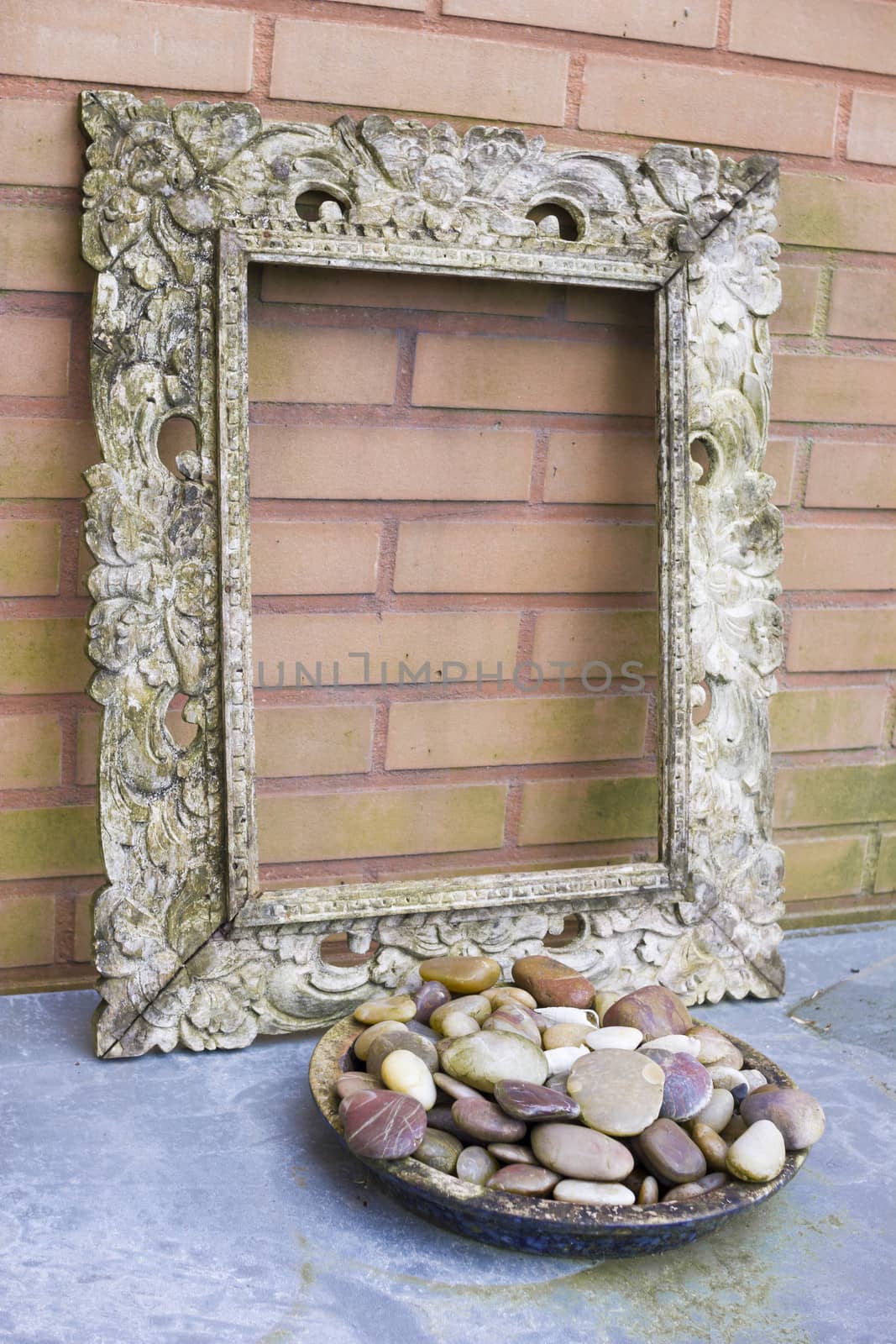 Wooden picture frame against  a brick background by Tetyana