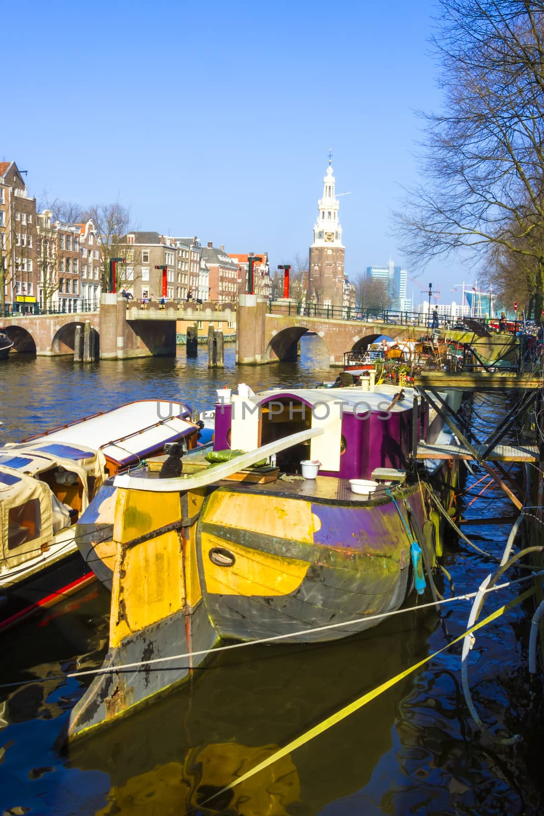 Typical Amsterdam canal with boat houses and a bridge