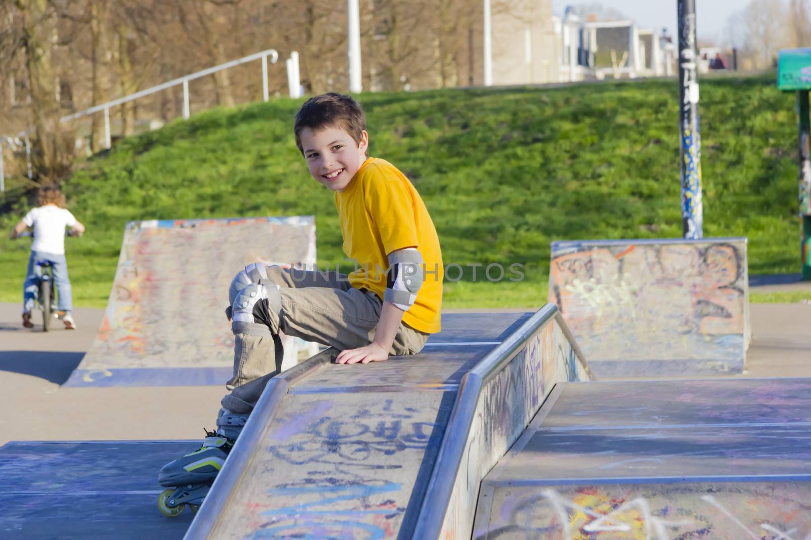 smiling teenage boy in roller-blading protection kit in a skate  by Tetyana