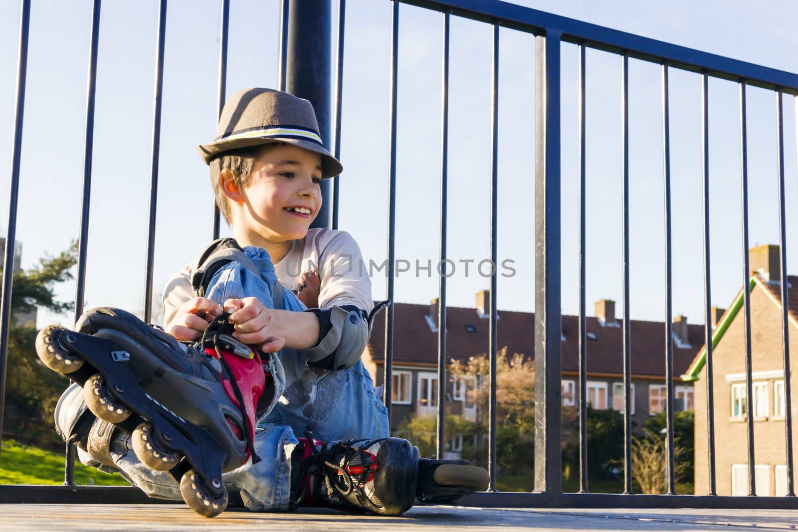 smiling teenage boy in roller-blading protection kit by Tetyana