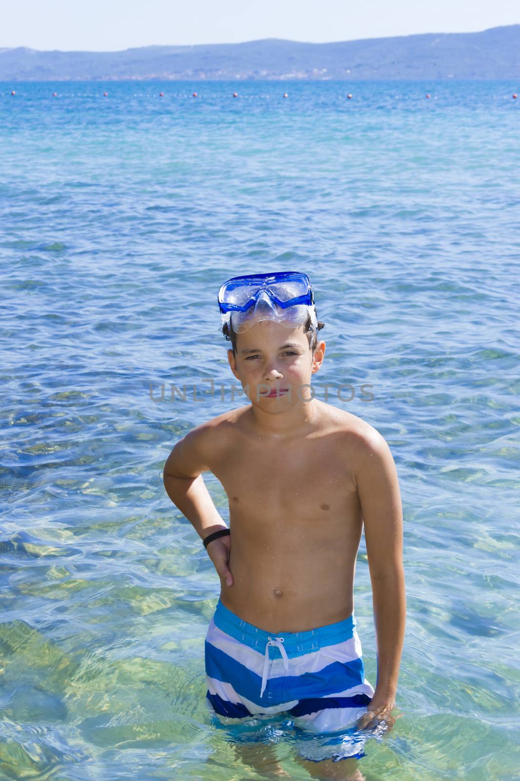 Cute eleven years old boy staying in the sea by Tetyana