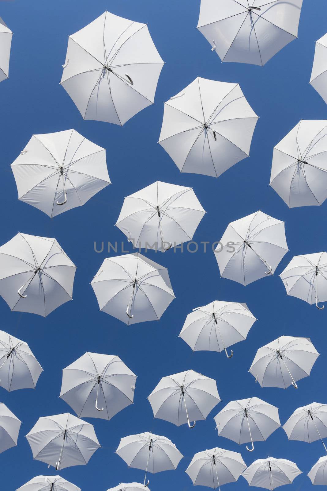 Ornamental white umbrellas flying in the blue sky