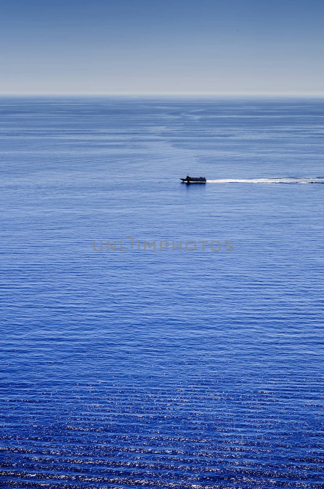 Sea landscape under the sun with waves, reflections and distant ships