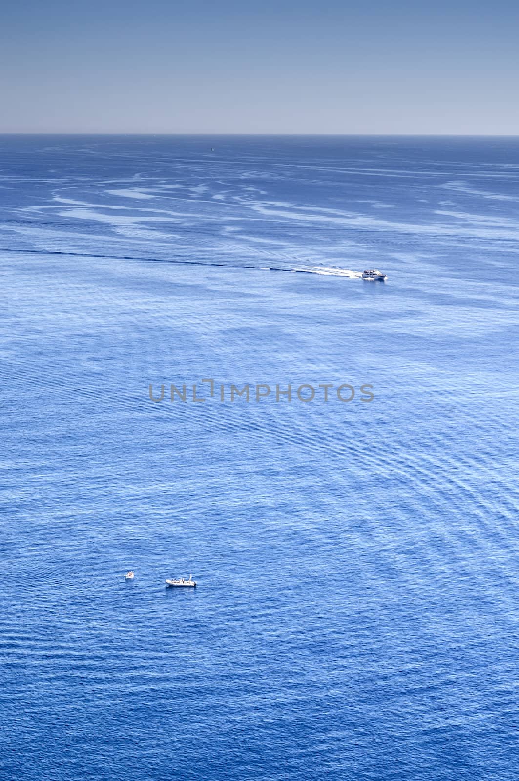 Sea landscape under the sun with waves, reflections and  ships and boats