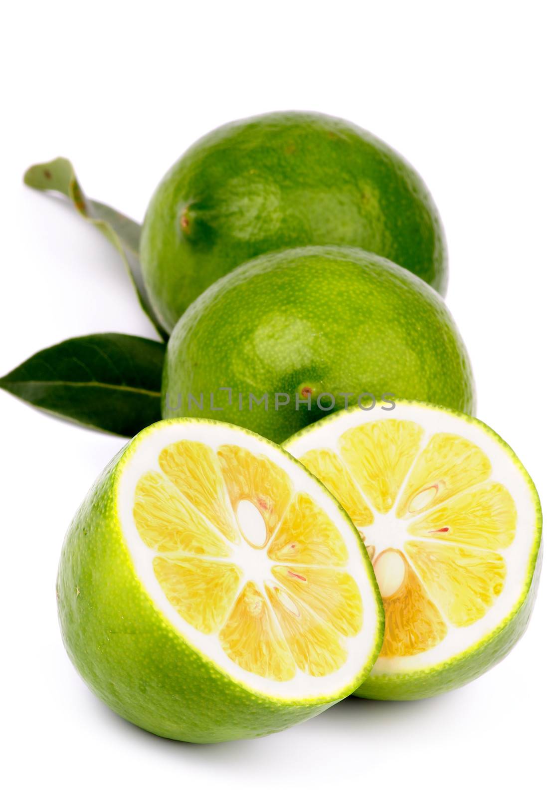 Arrangement of Fresh Ripe Green Lemons Full Body and Halves with Leafs isolated on white background