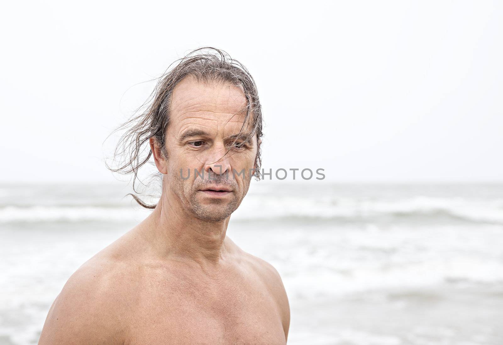 Portrait of middle-aged men with long hair on the sea background