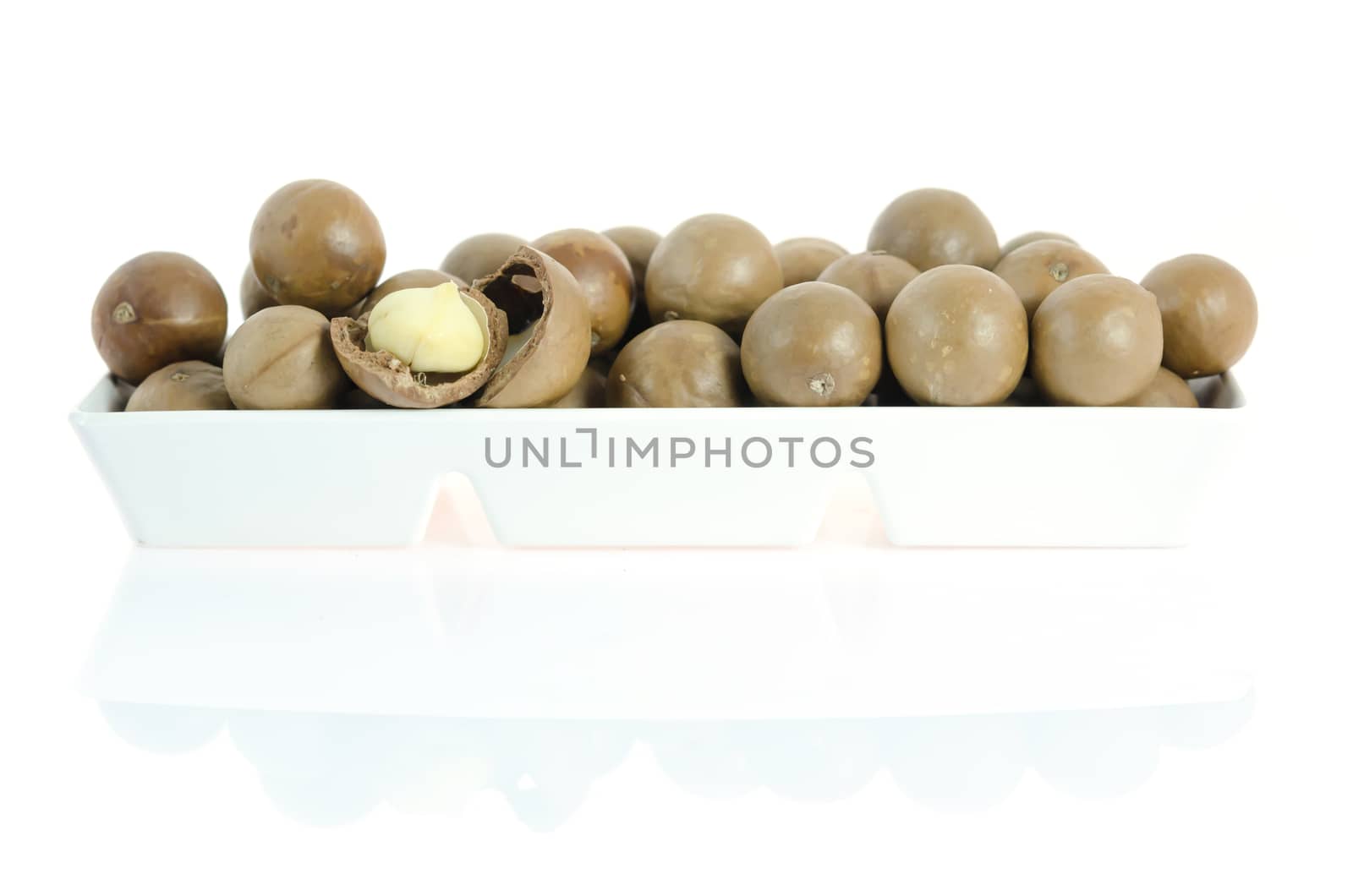 macadamia in  white bowl  on white background with reflection