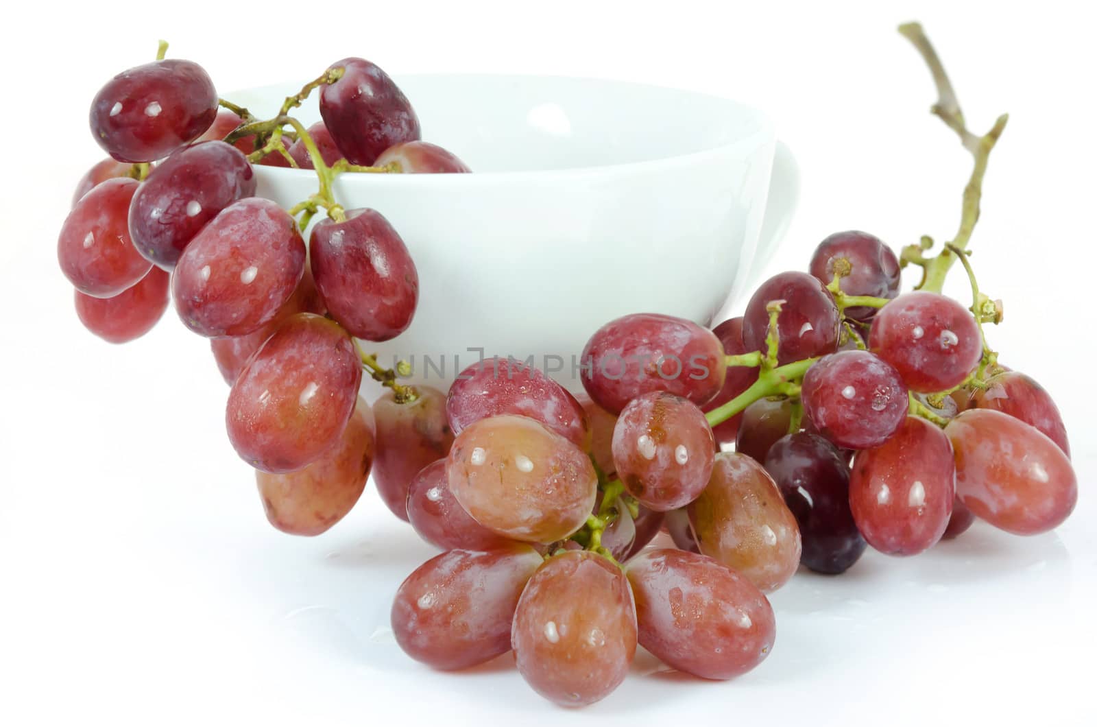 ripe fruits in white bowl ( grape) over white background