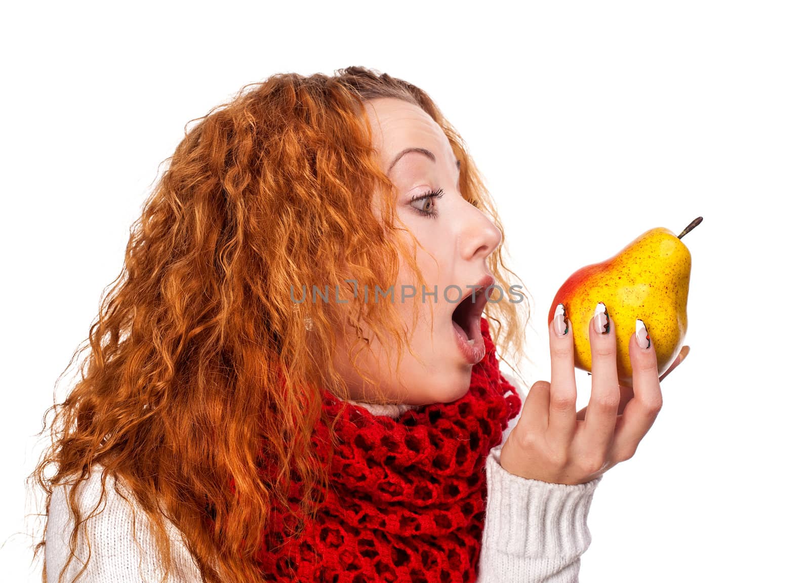 Redheaded girl wants to eat a pear isolated on white