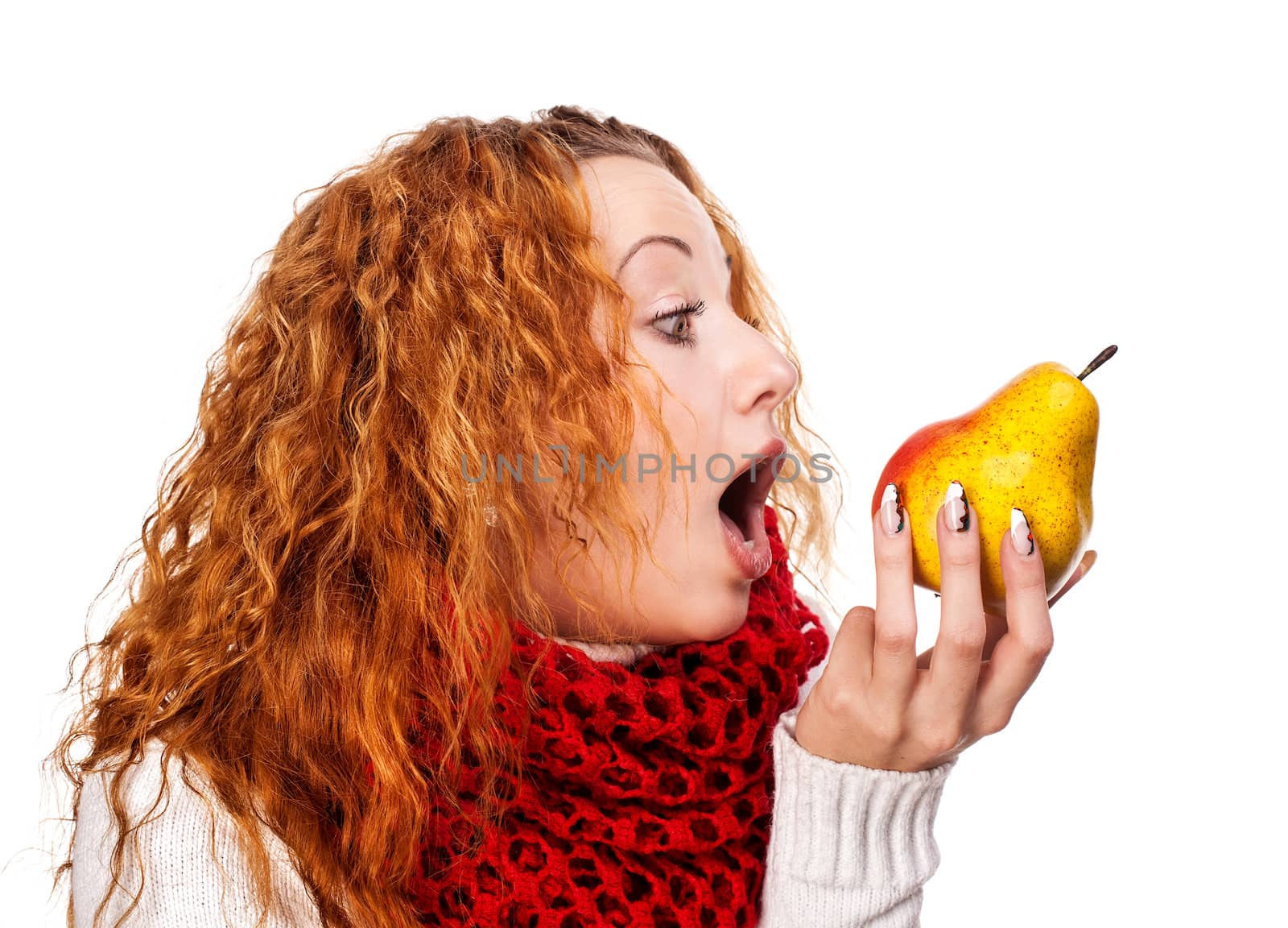 Redheaded girl wants to eat a pear isolated on white