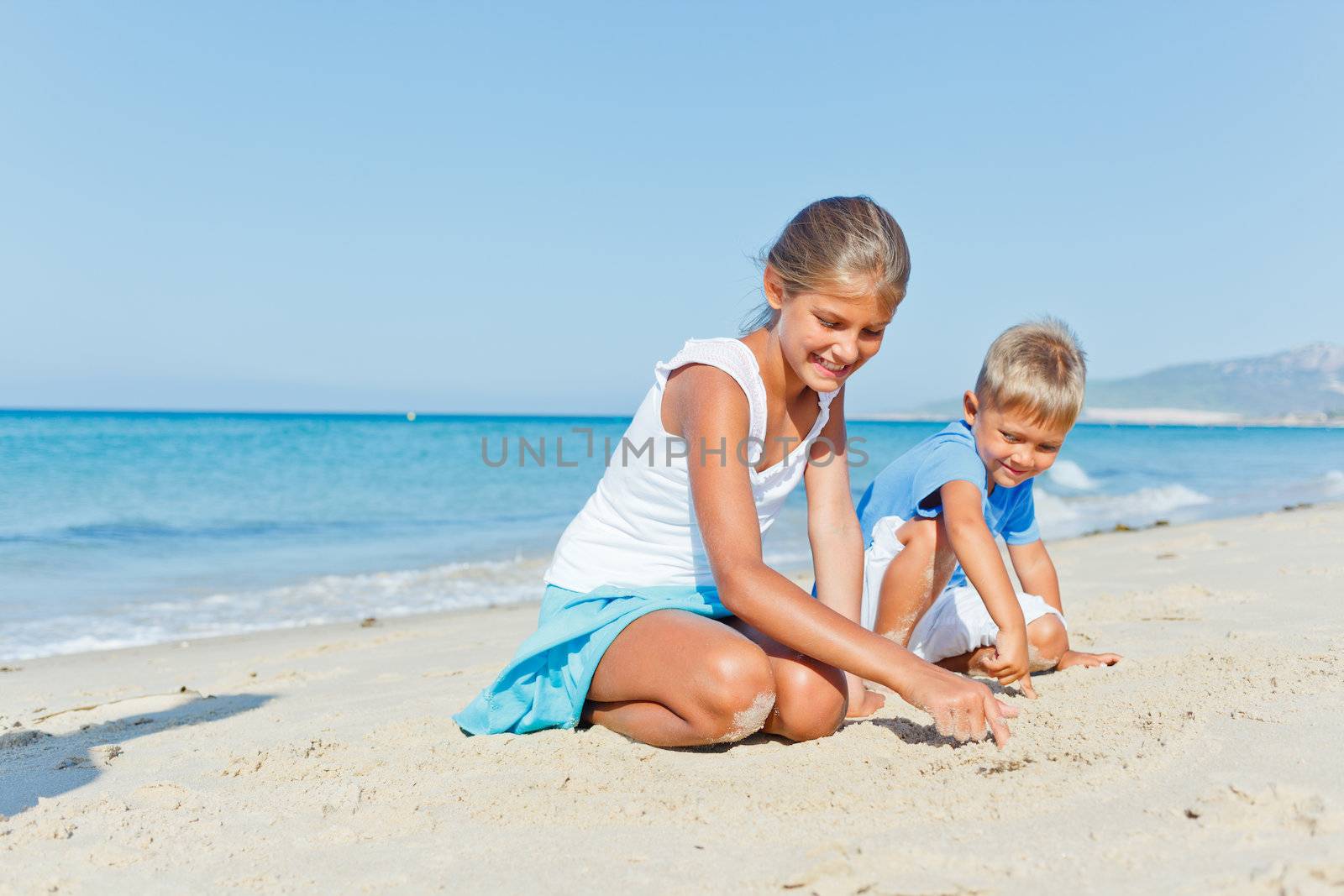 Two cute kids playing on tropical beach