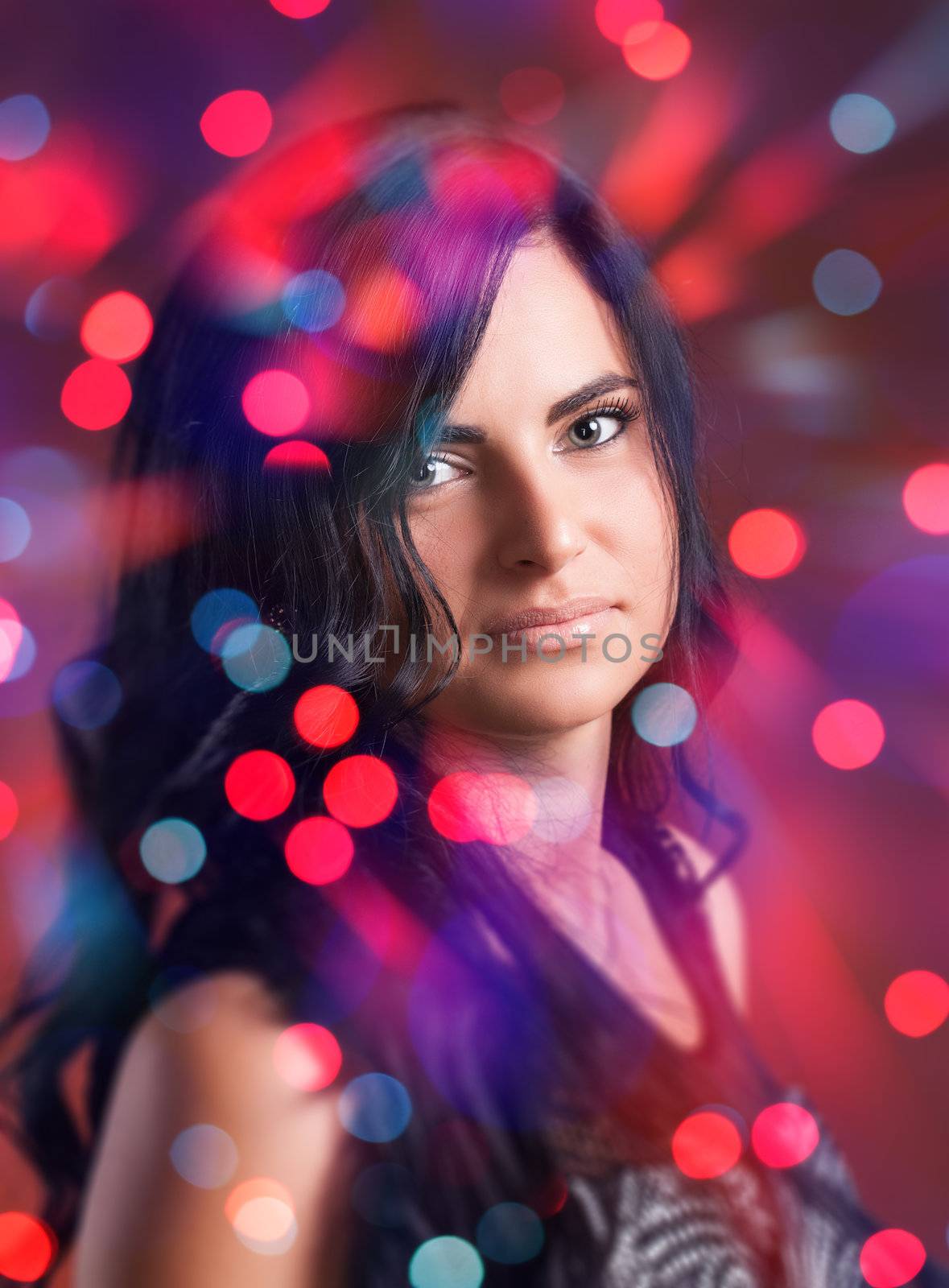 Portrait of attractive brunette girl with bokeh lights on background