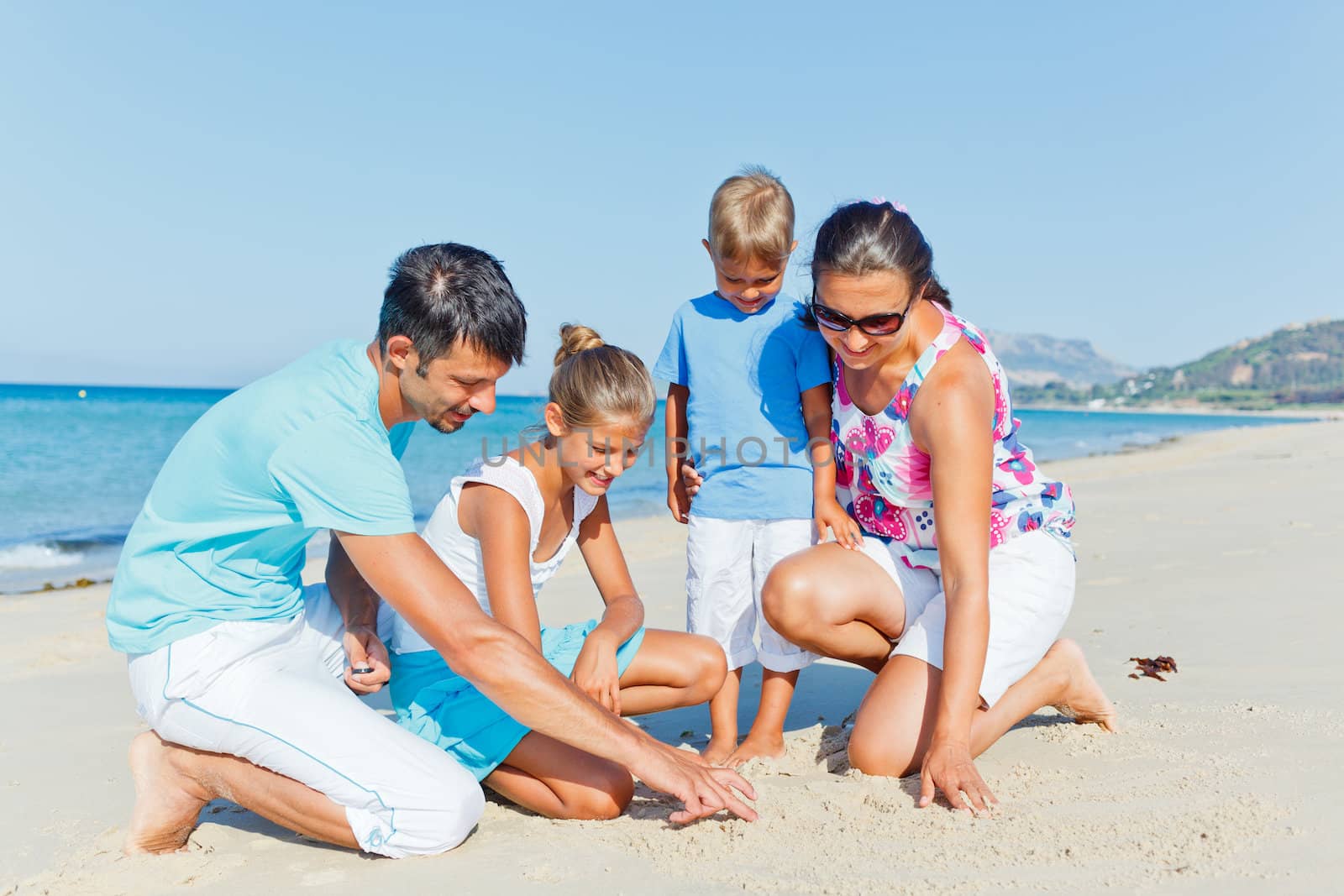 family having fun on beach by maxoliki