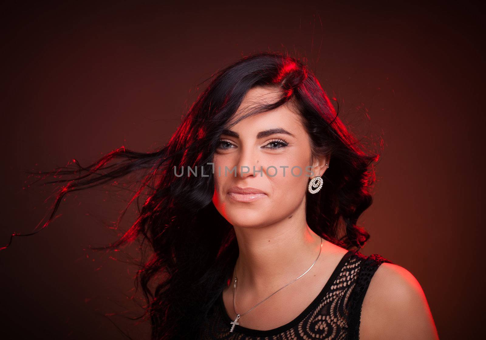 Beautiful smiling young woman with hair blowing on wind