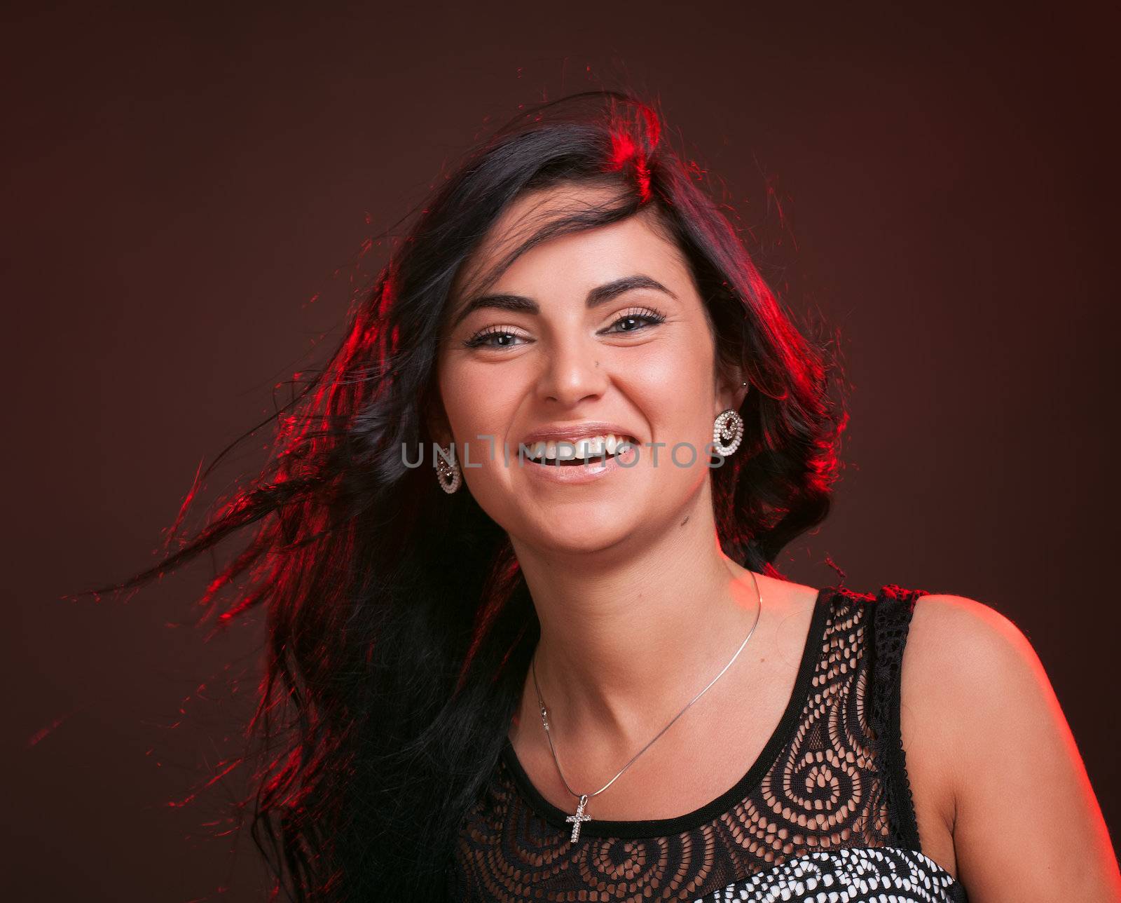 Beautiful smiling young woman with hair blowing on wind