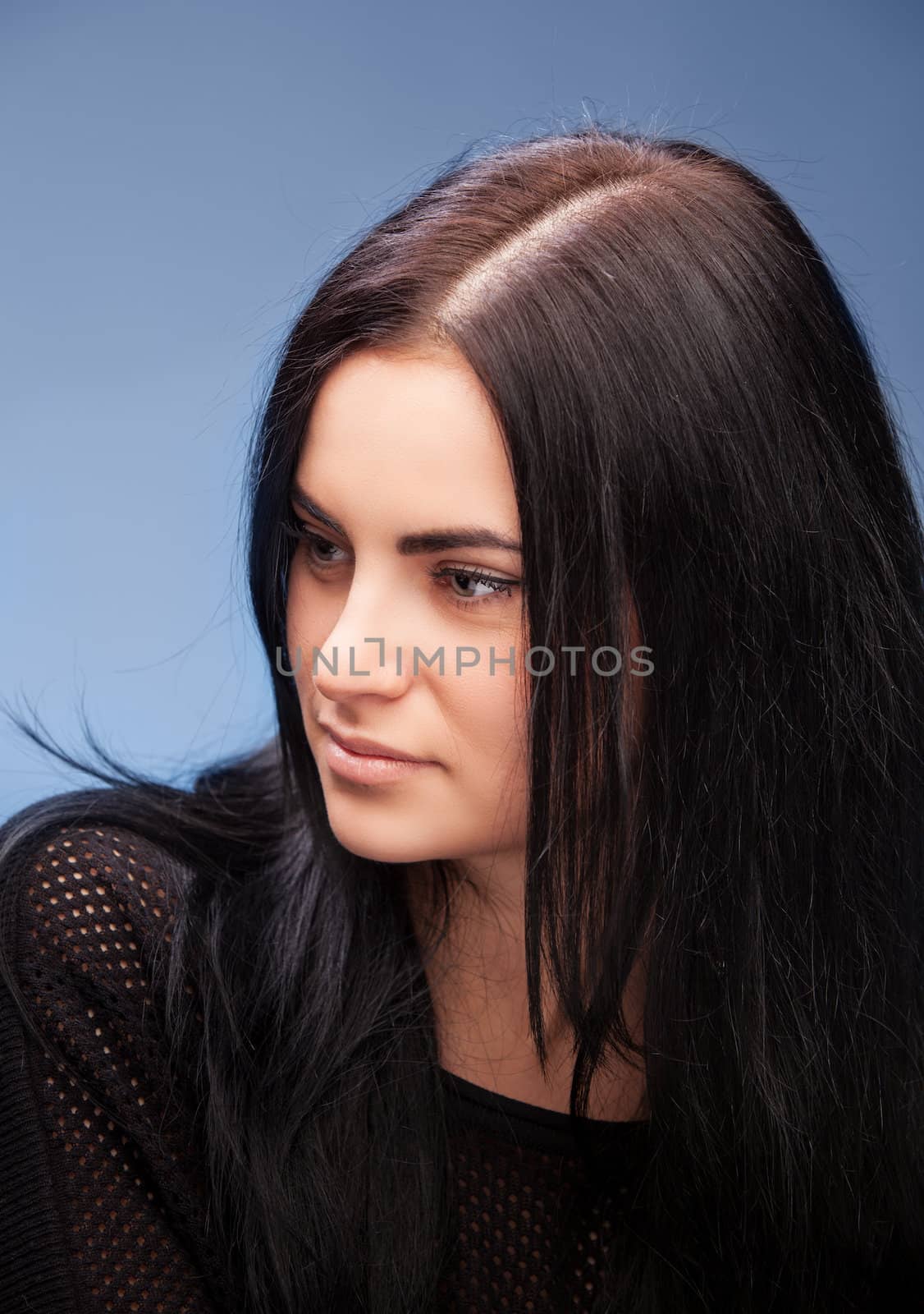 close up portrait of a brunette beautiful girl on blue
