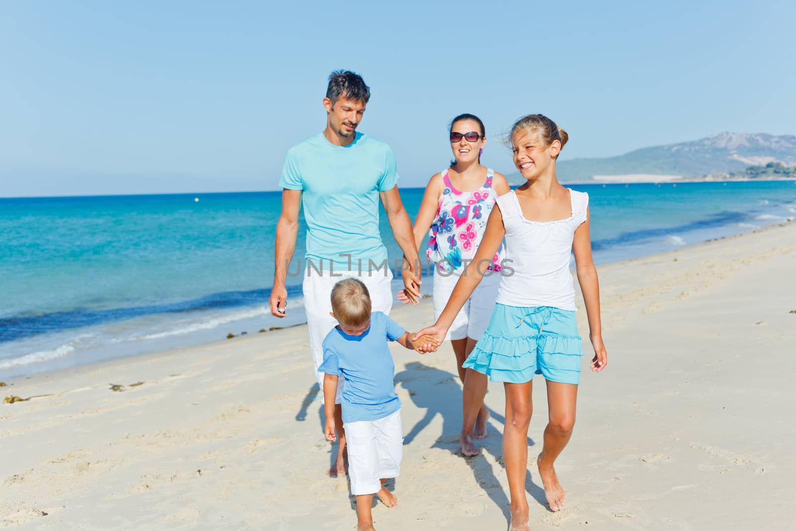 Family of four having fun on tropical beach