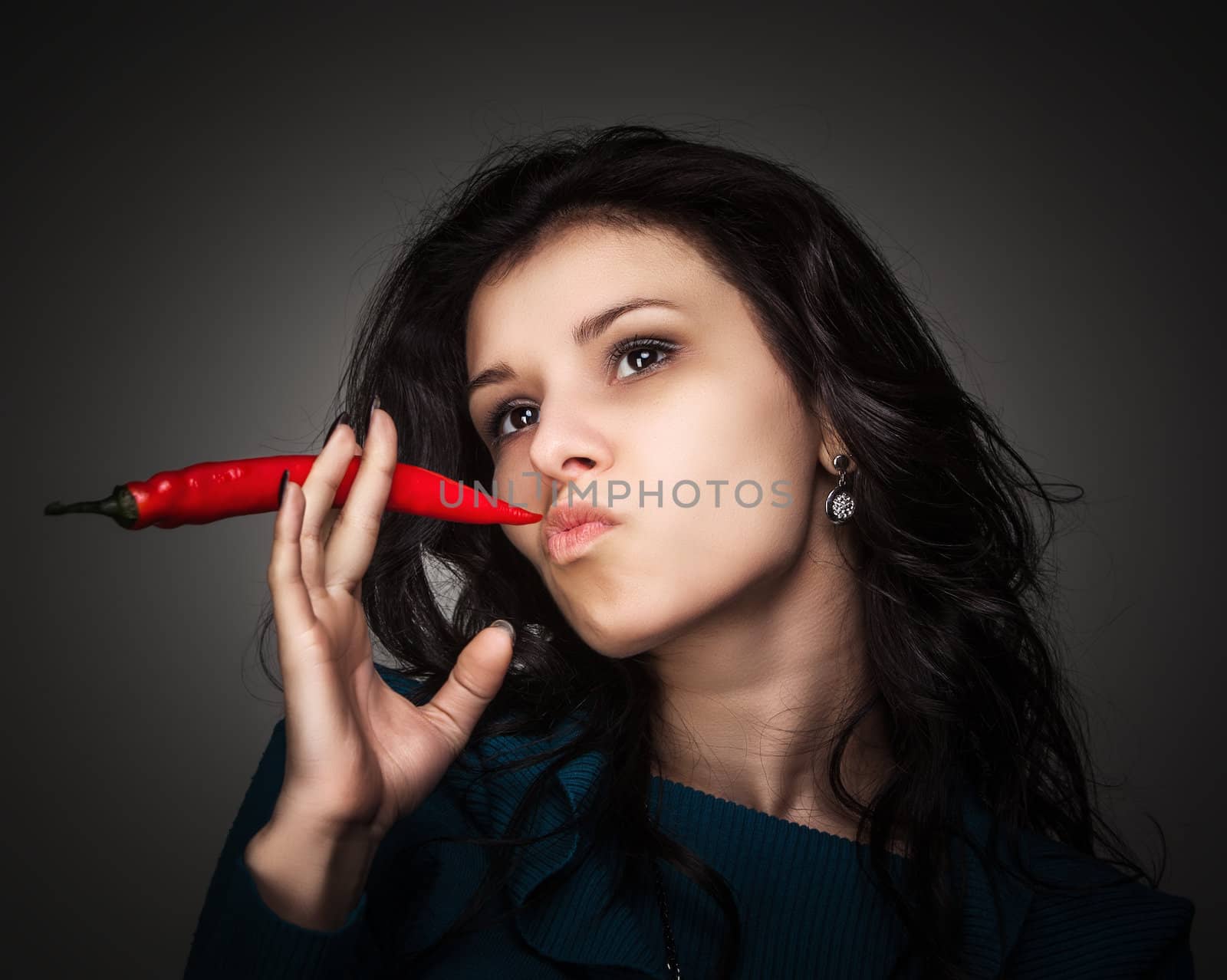 woman holding red hot chili pepper in mouth by palinchak