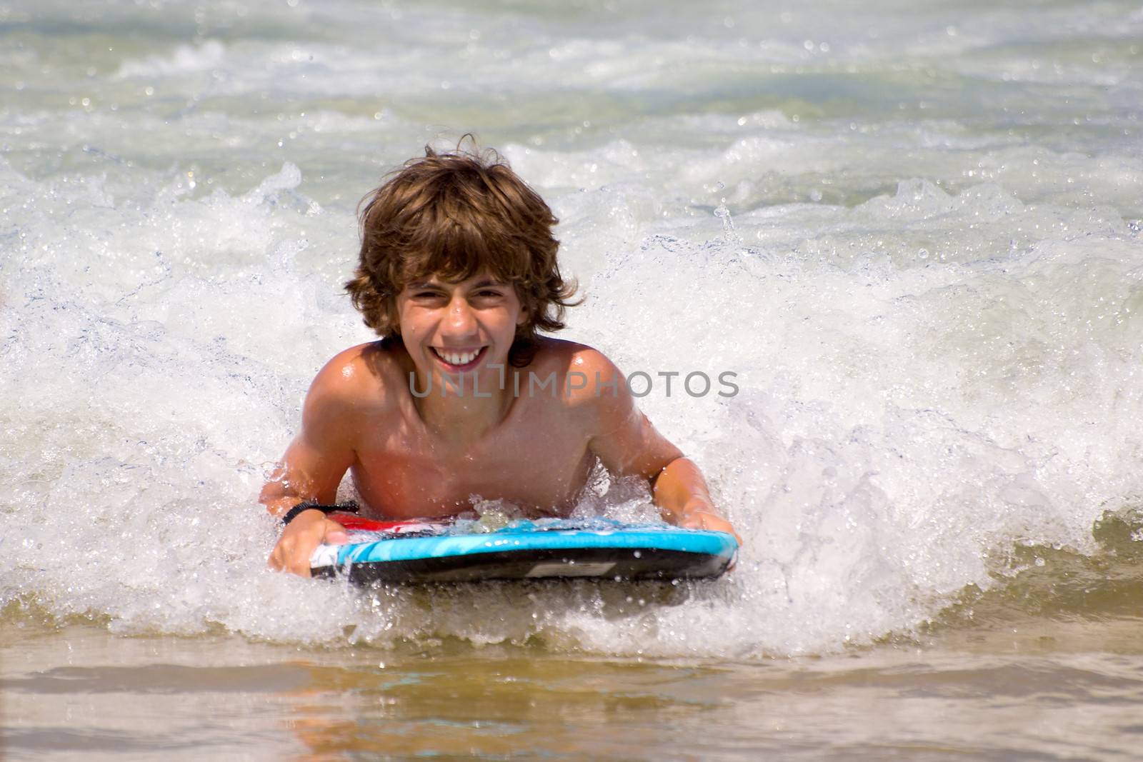 a boy with a body board in the sea