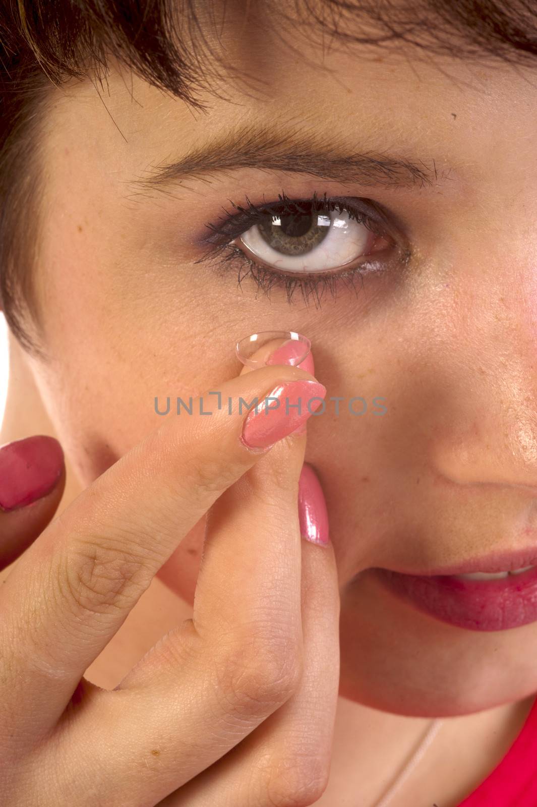 Closeup of a woman inserting a contact lens in her eye