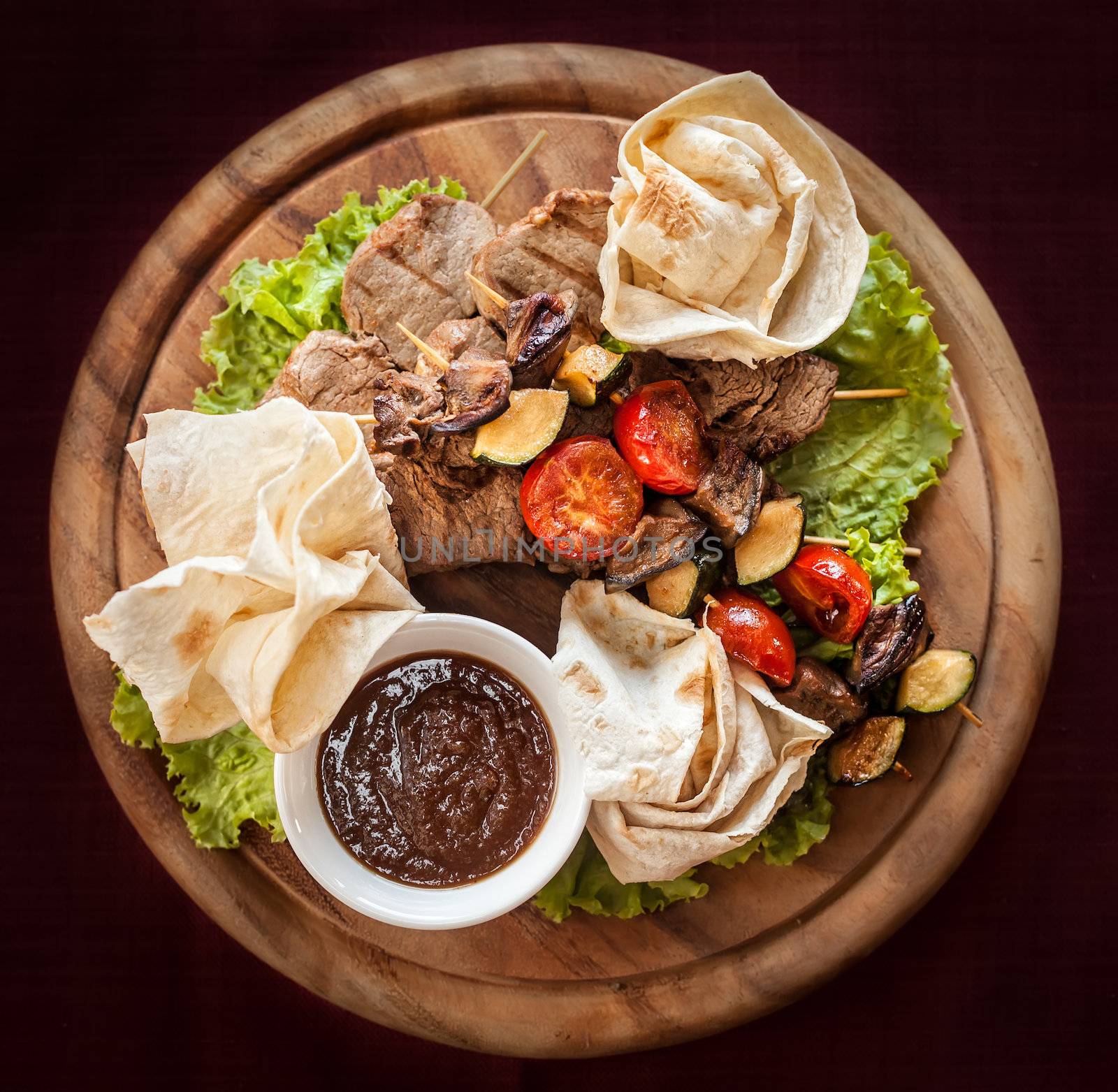 Meat and vegetable delicacies served on a wooden tray