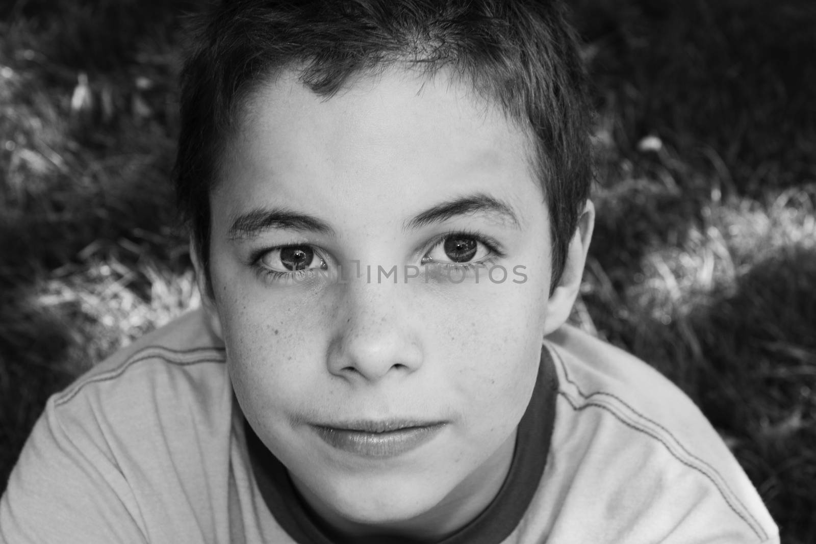 Cute boy smiling at camera in the park on a sunny day