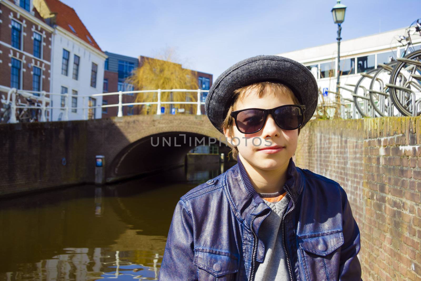 Handsome boy in sunglasses against canal background