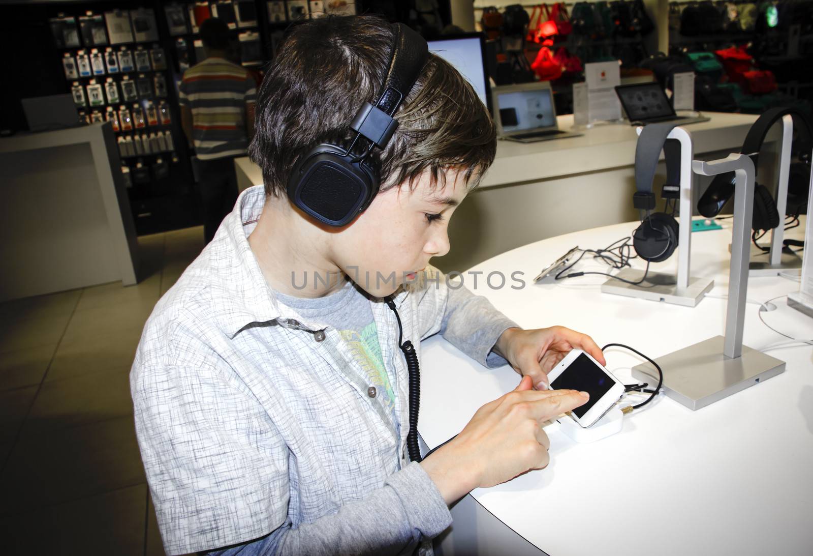 Portrait of a sweet young boy listening to music on headphones  by Tetyana
