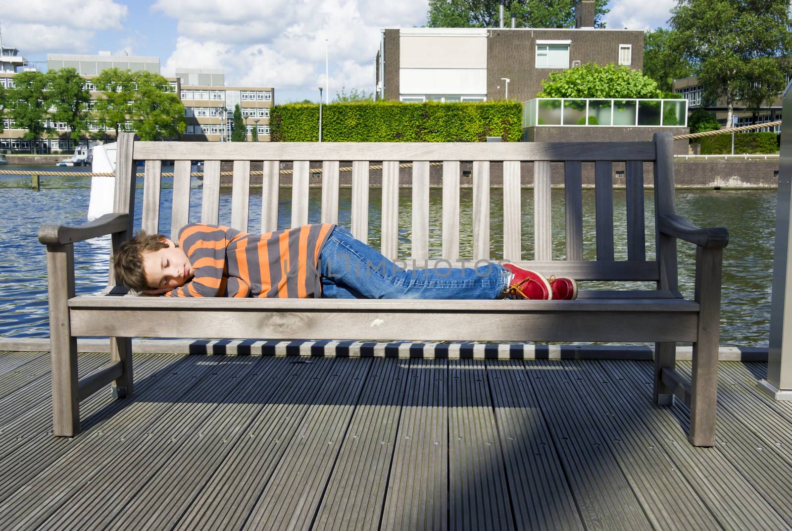 relaxed boy sleeping on the bench by Tetyana