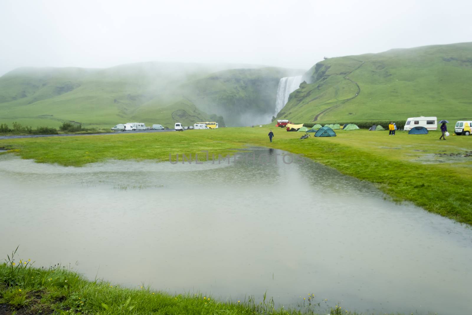 tent camp near Skogarfoss waterfall in Iceland, rainy summer by Tetyana