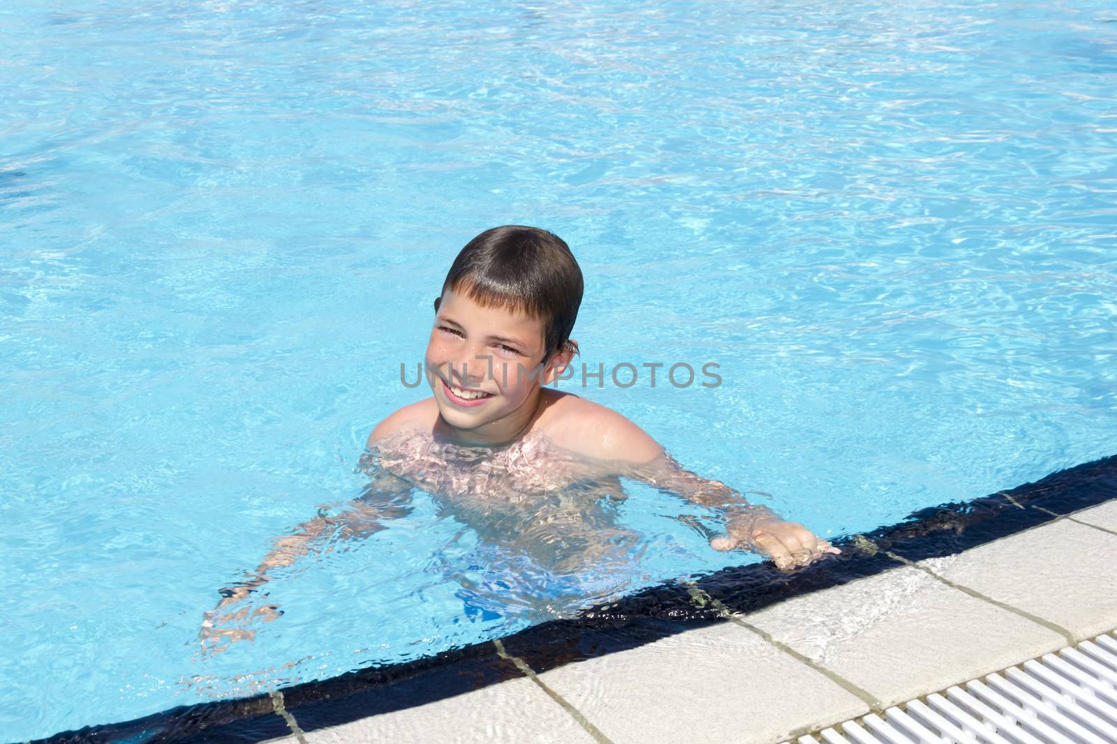 Activities on the pool. Cute boy swimming and playing in water i by Tetyana