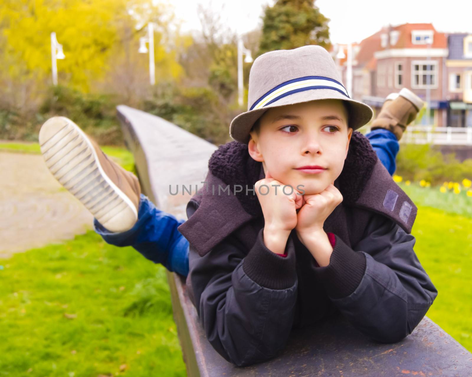 Cute teenage boy lying on the parapet at the park
