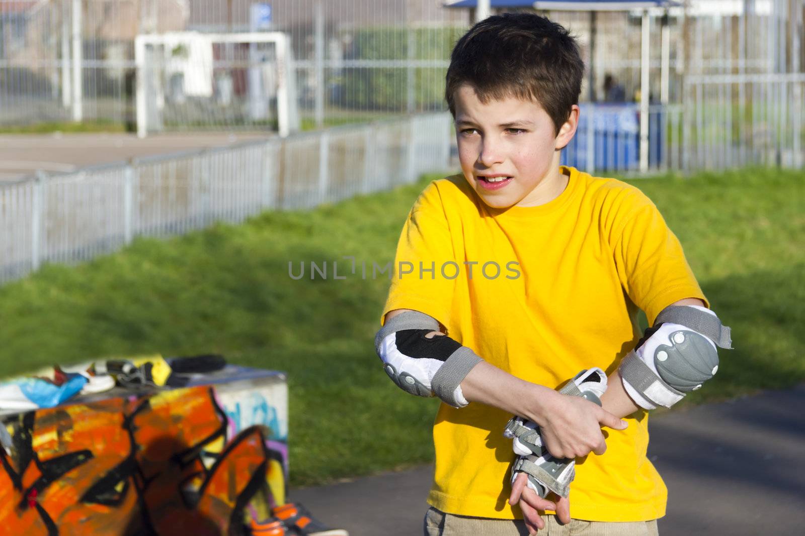 The boy puts on intently roller protection kit