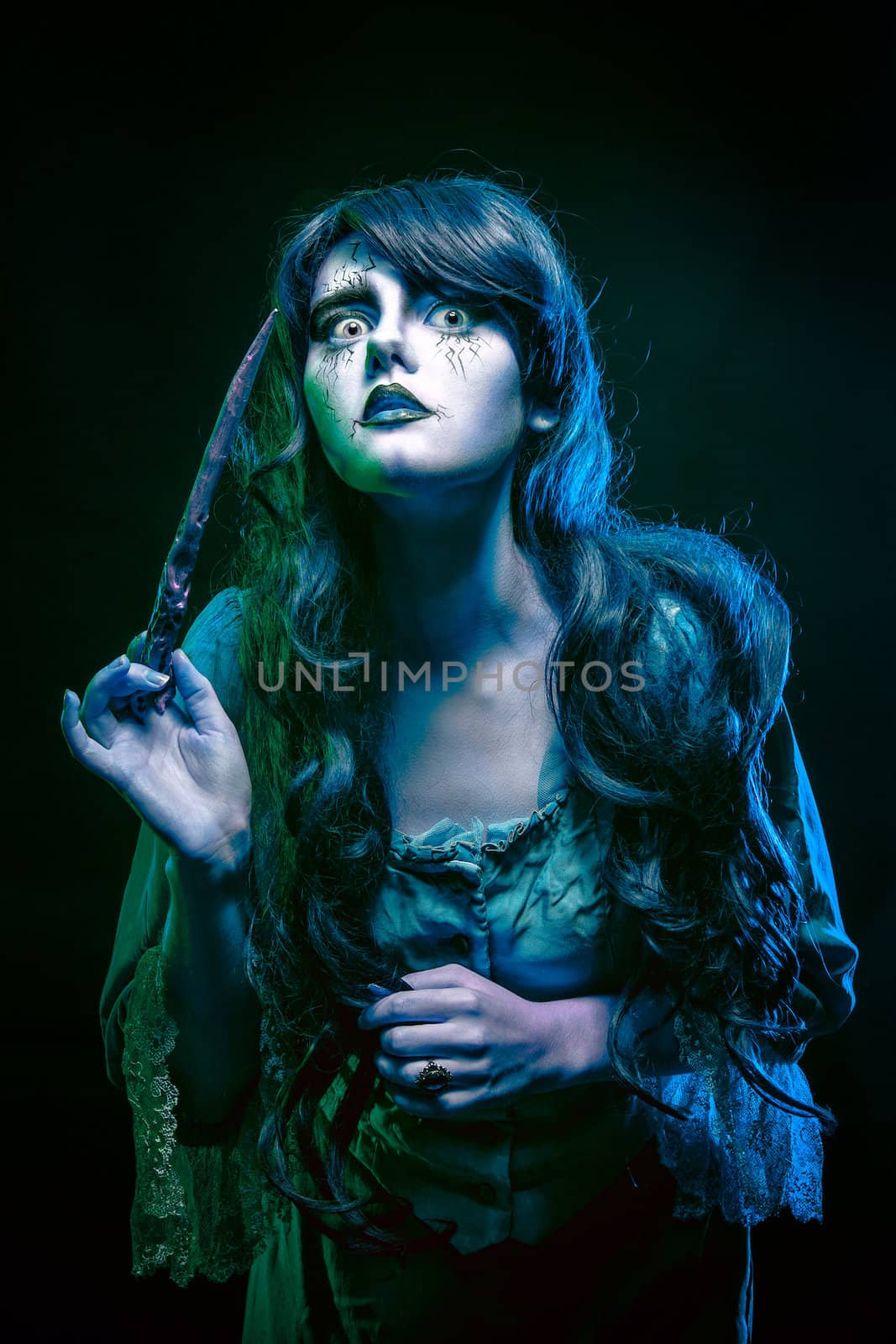 Girl in the image of a witch with a magic wand shot in studio