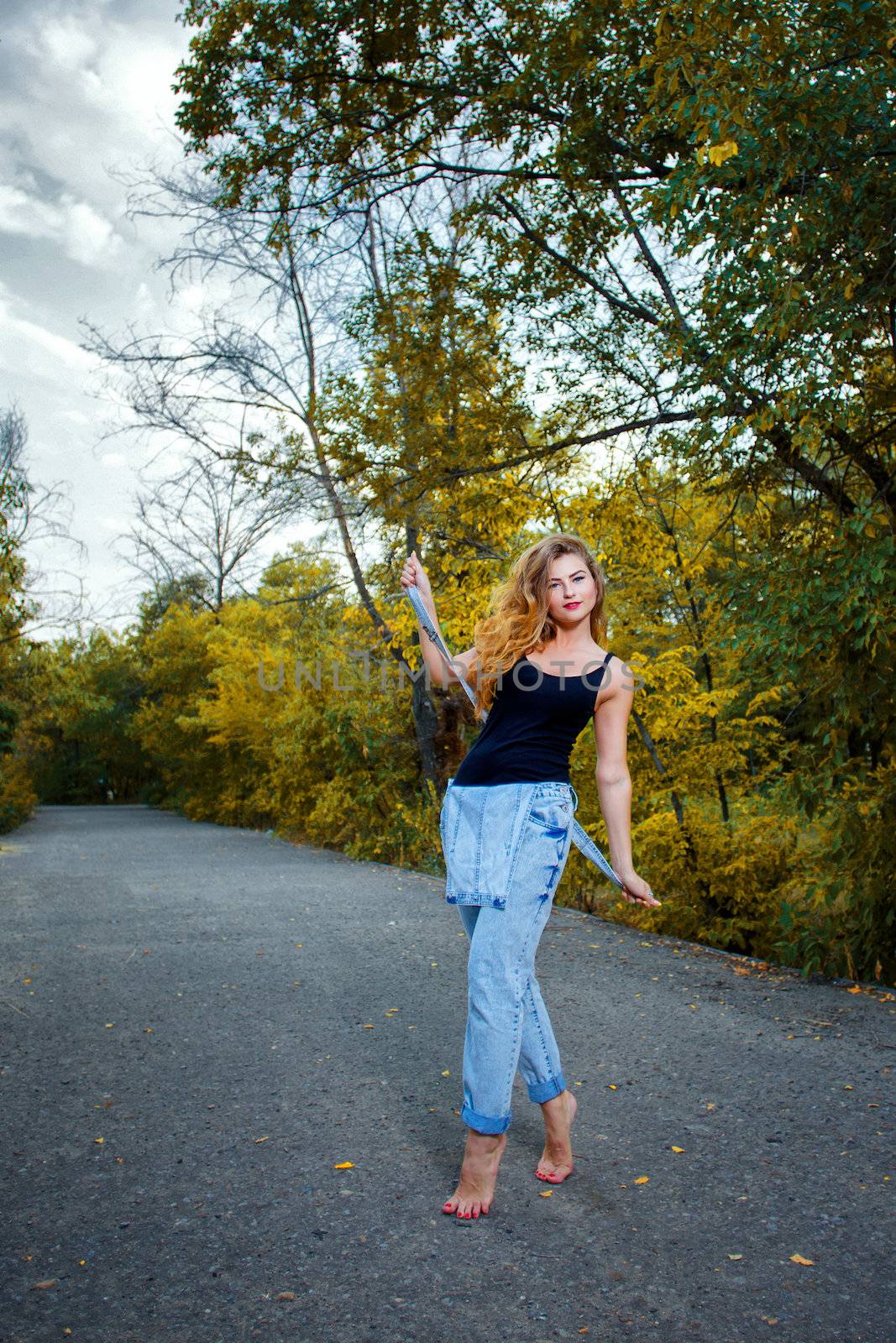 Beautiful pin-up girl in denim overalls and a T-shirt outdoors