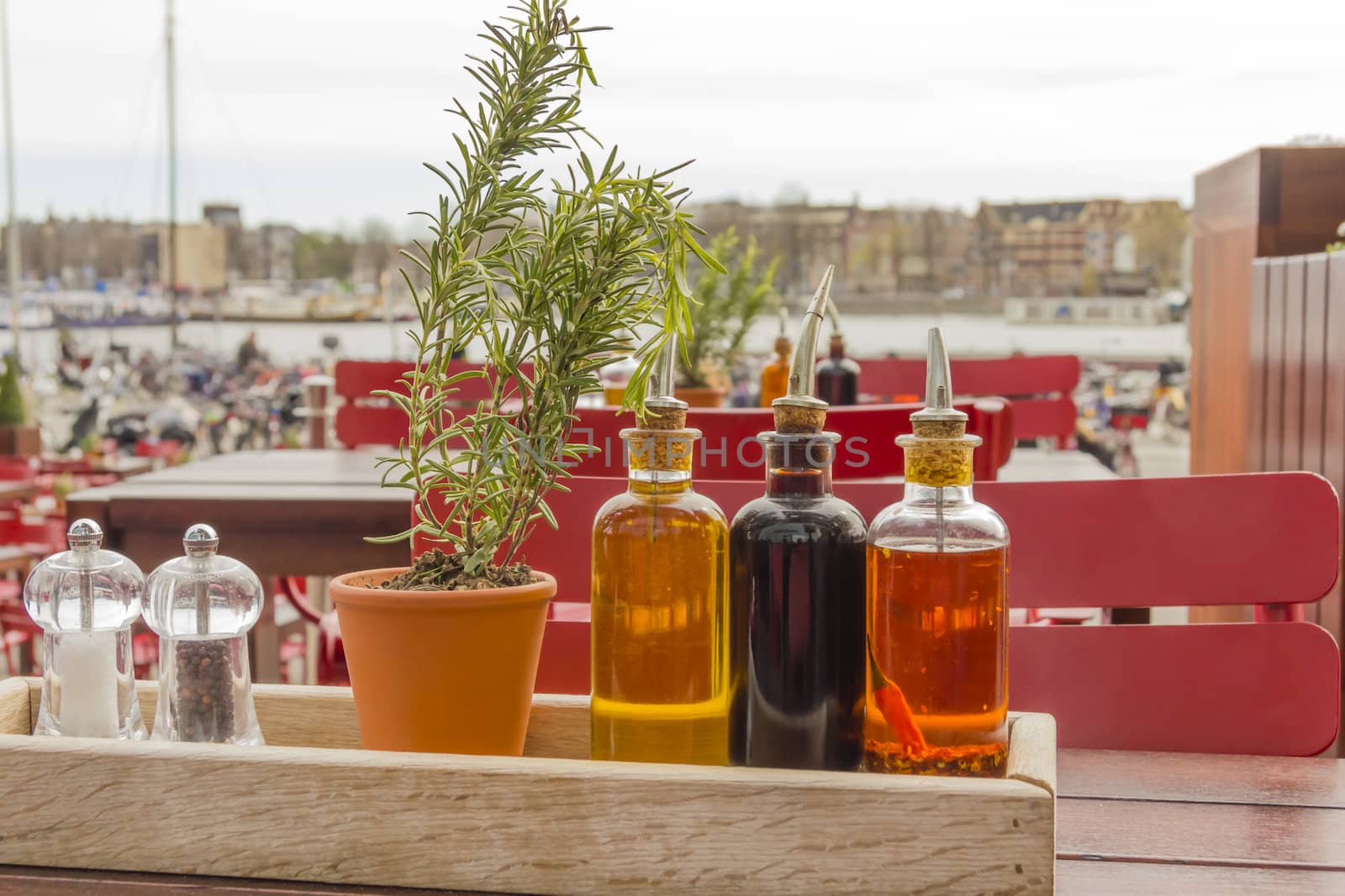 balsamic vinegar bottles and condiments on the table in an open  by Tetyana