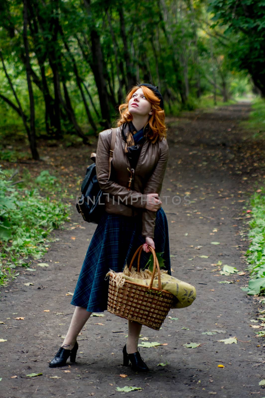 Portrait of a beautiful redhair girl in the autumn park. Caucasian race.