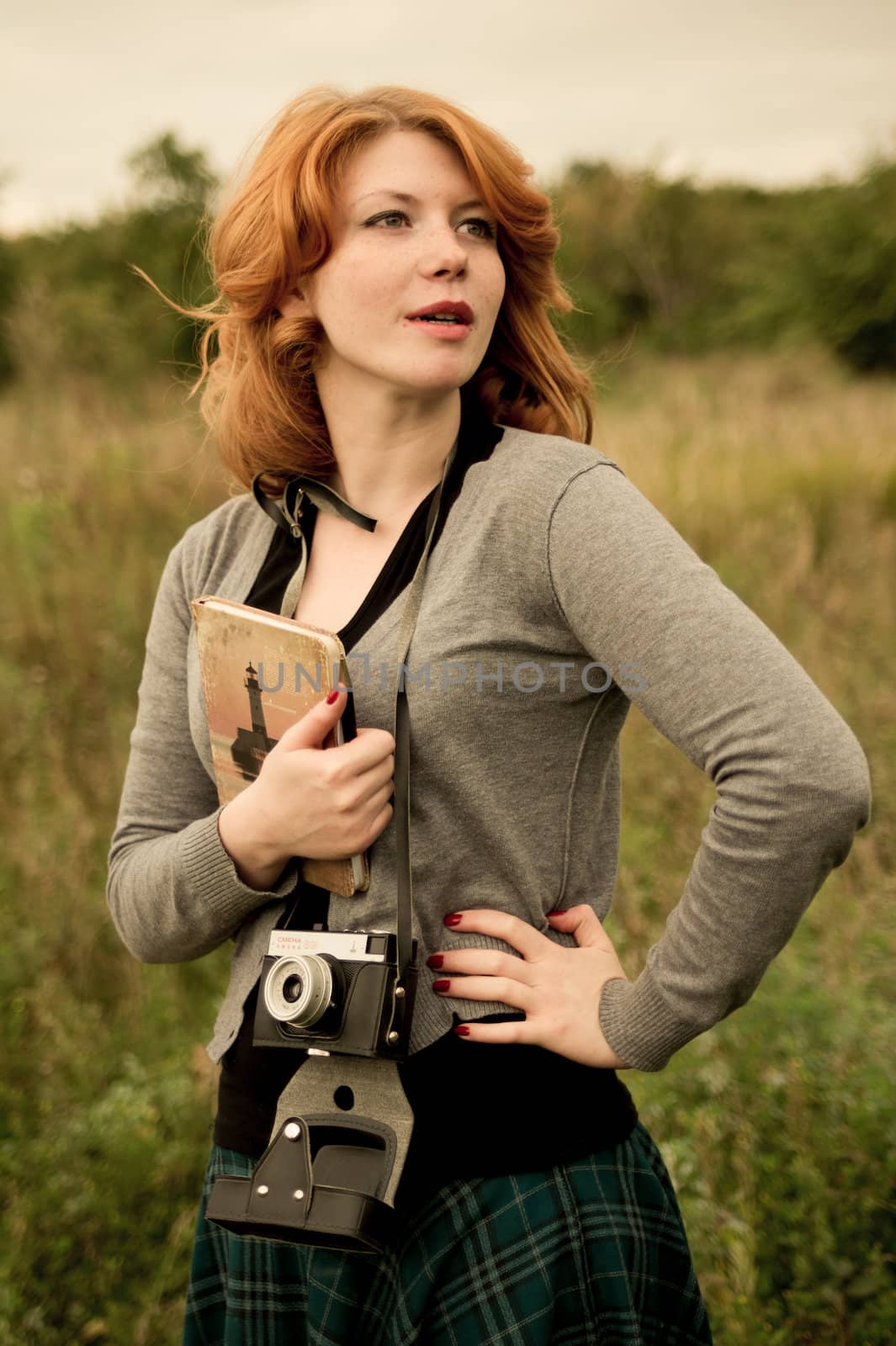 Portrait of a beautiful redhair girl in the autumn park. Caucasian race.