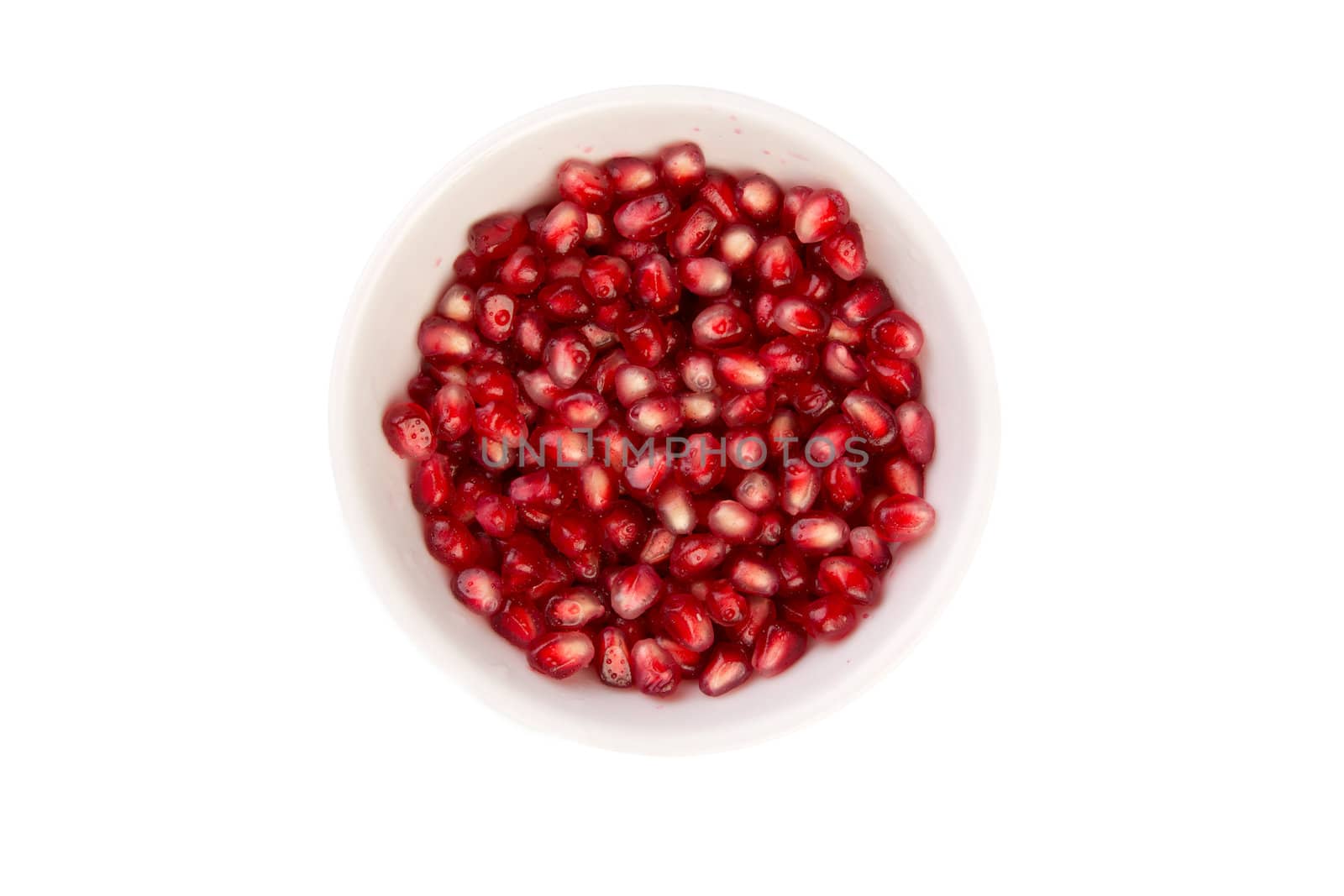 Wet pomegrenate seeds in a white bowl, macro shot from above, isolated on white