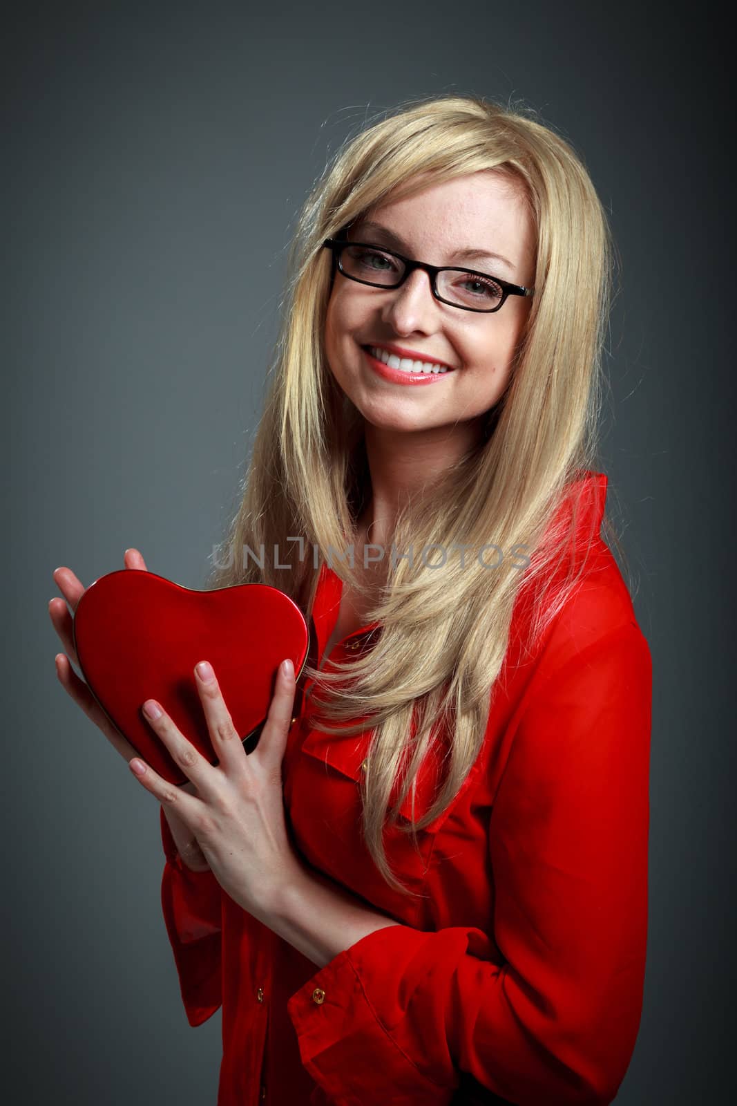 Attractive caucasian blond girl isolated on a grey background