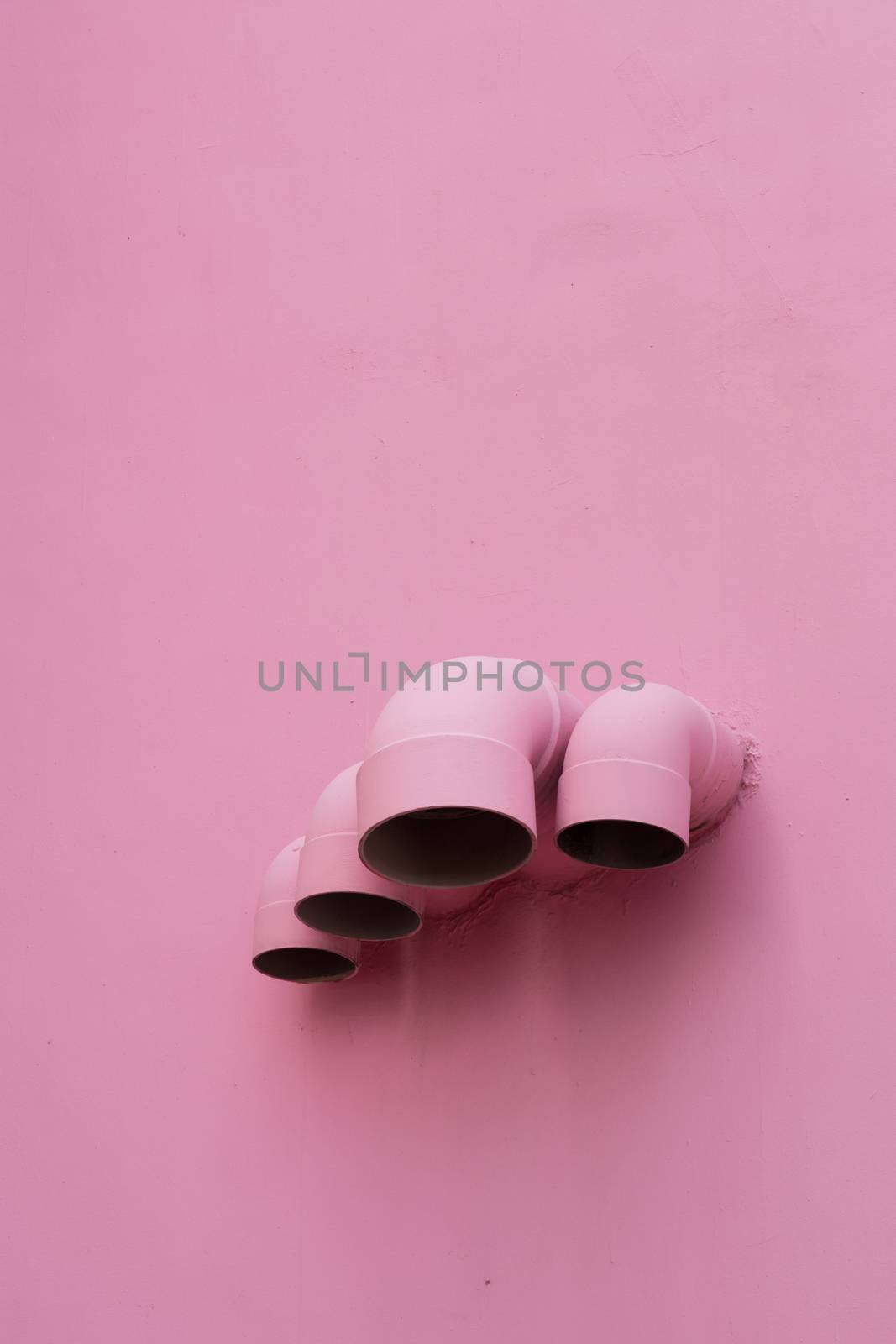 Pink pipes on wall of a building
