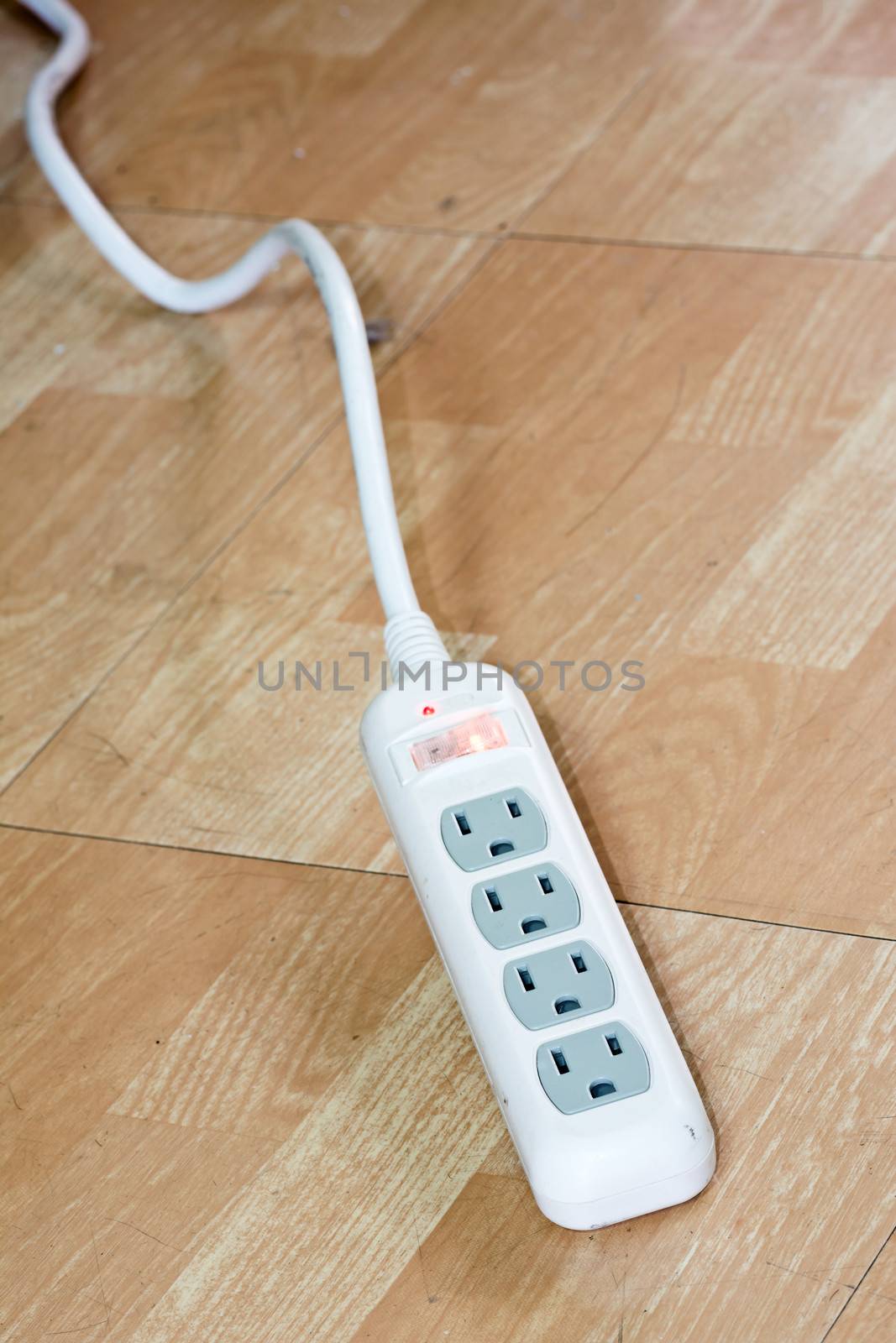White power strip or extension block laying on the floor.