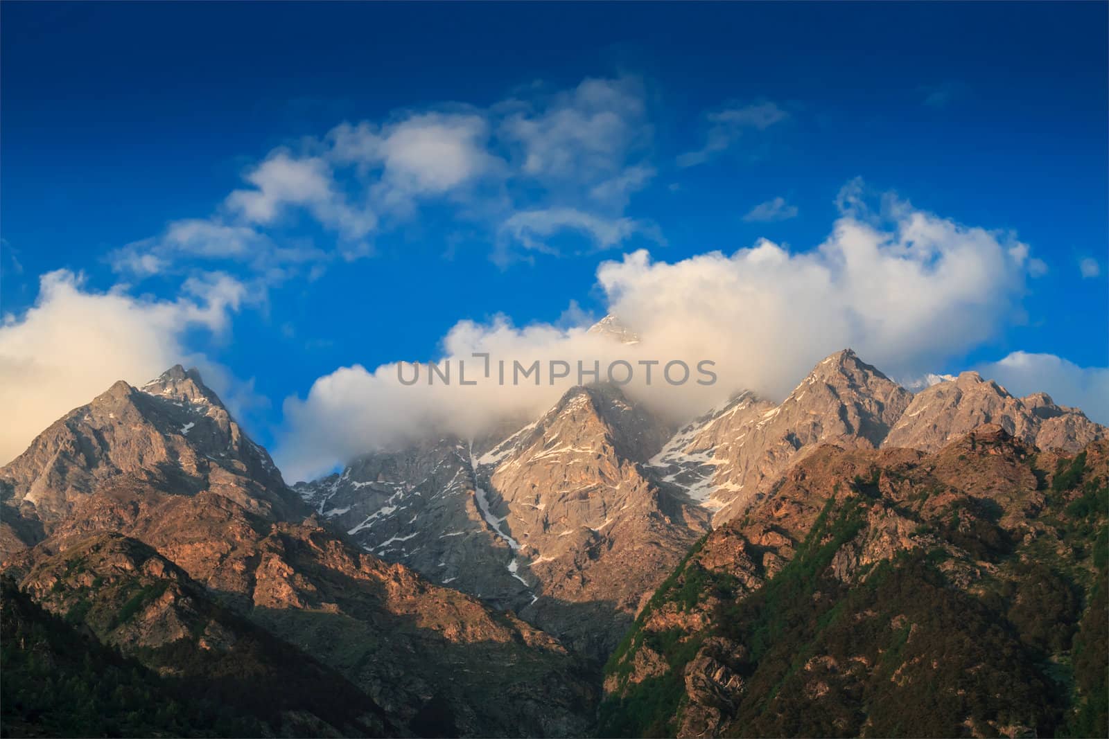 Himalayas summits in clouds on sunset by dimol