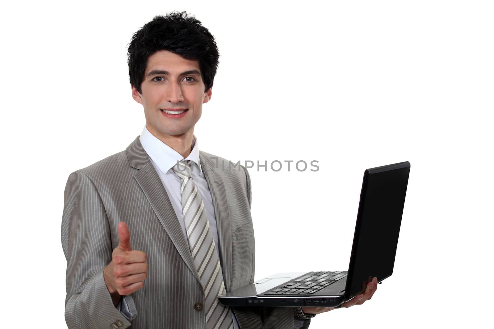 businessman holding a laptop and making a thumbs up sign by phovoir