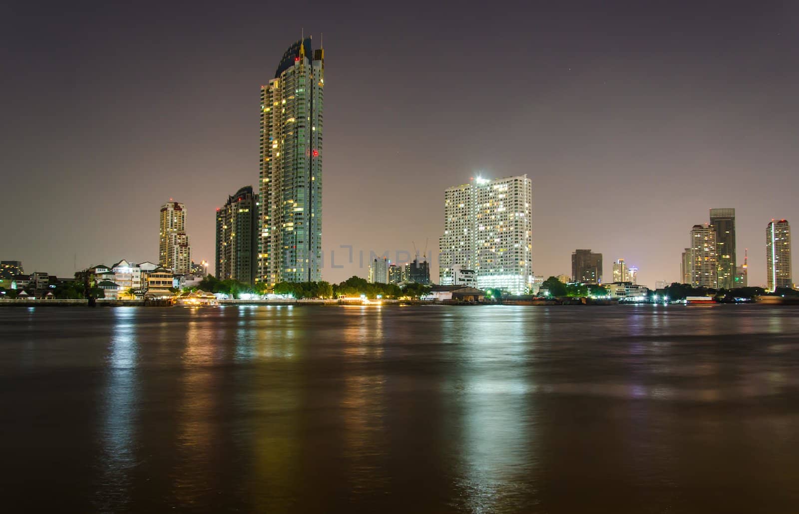 Riverside buildings at night in Bangkok, Thailand.
